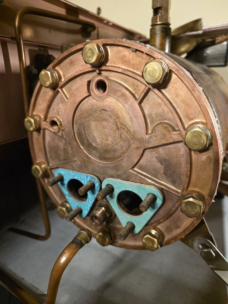 Copper boiler flange with fresh gaskets and new studs during restoration