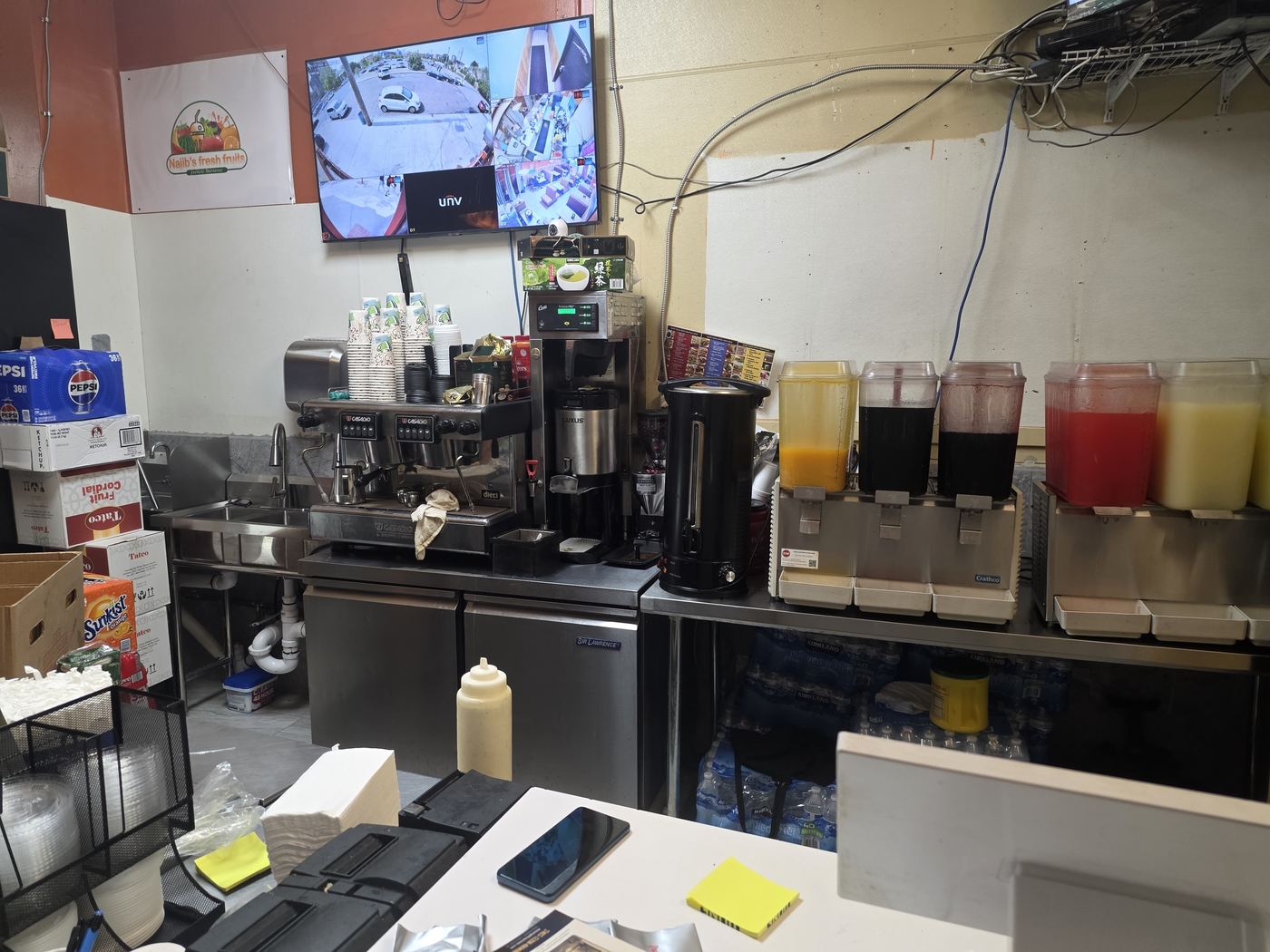 Espresso and juice bar service counter fully stocked with cups, syrups, and refresher dispensers